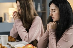 side-view-women-praying-before-dinner