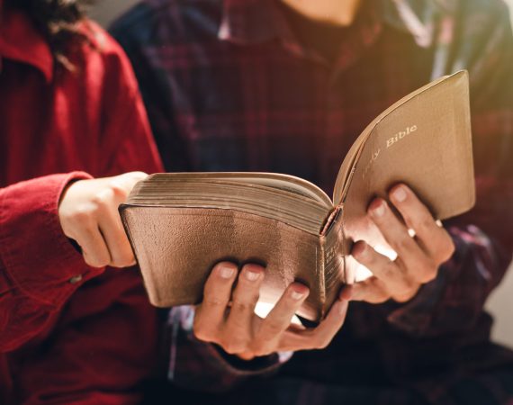 A woman and two men were studying and reading the Bible. That is Christian love